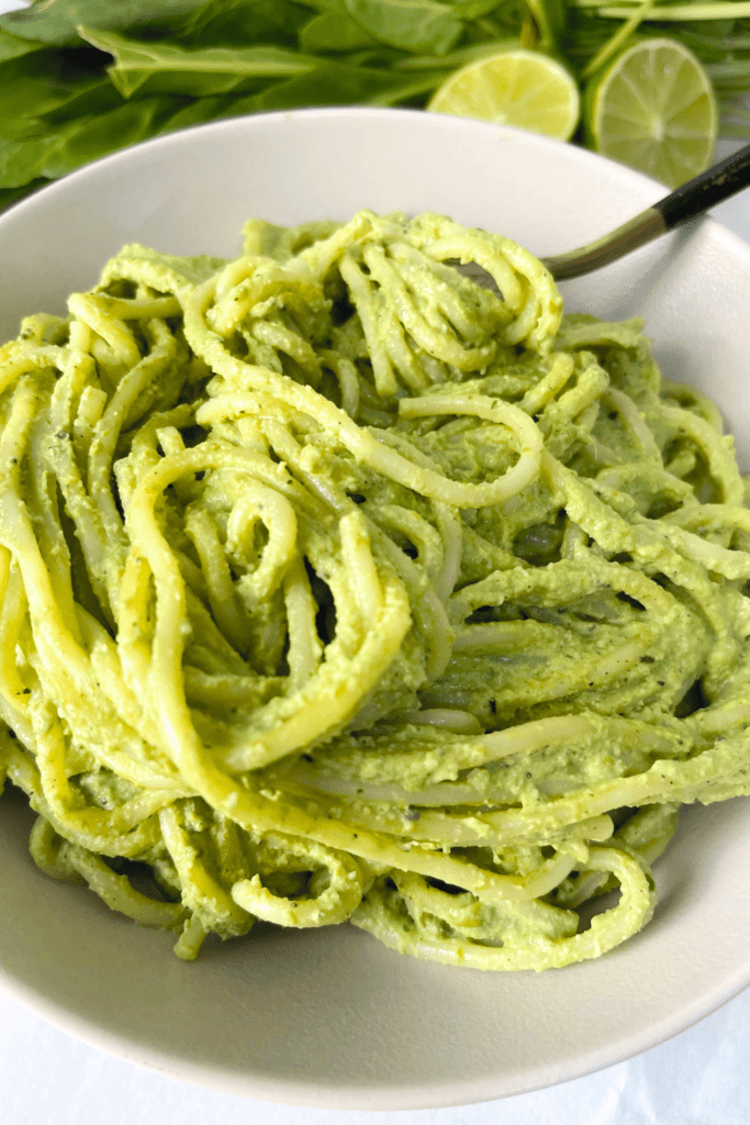 green pasta sauce spaghetti in a white bowl